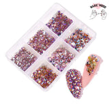 Une boite de strass en verre de cristal pour ongles, de toutes les couleurs. Strass à coller sur les ongles ou les faux, pour un joli nail art. Nuancé de rose et violet.