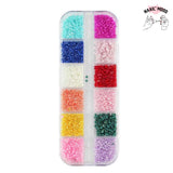 Boite de perles pour nail art et décoration sur ongles. 12 fentes et 12 coloris différents, bleu clair et foncé, rouge, rose, blanc, orange, jaune, violet.